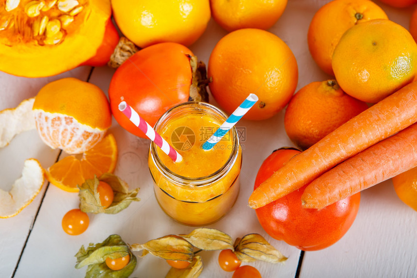 新鲜的有机橙色冰沙配南瓜胡萝卜酸浆橘子和柿子水果素食和健康的健图片