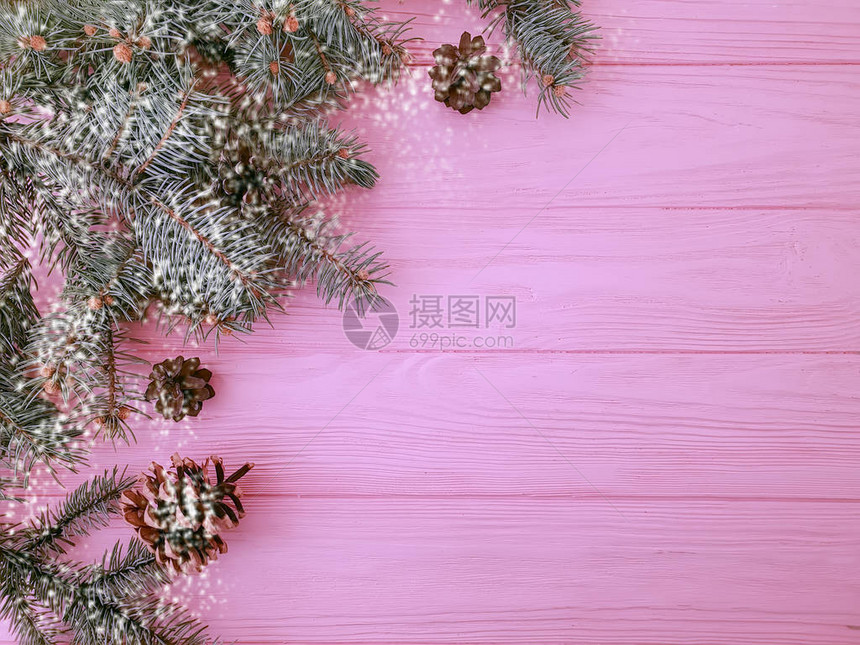 圣诞树枝粉红色木质背景上的一个凸起图片