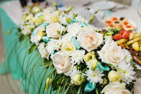 婚礼桌上的绿色和白色花朵图片