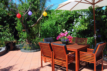 美丽而郁葱的庭院花园配有木桌和椅子图片