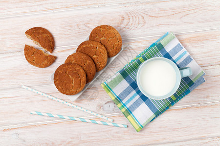 白色木桌上的一杯牛奶和饼干图片