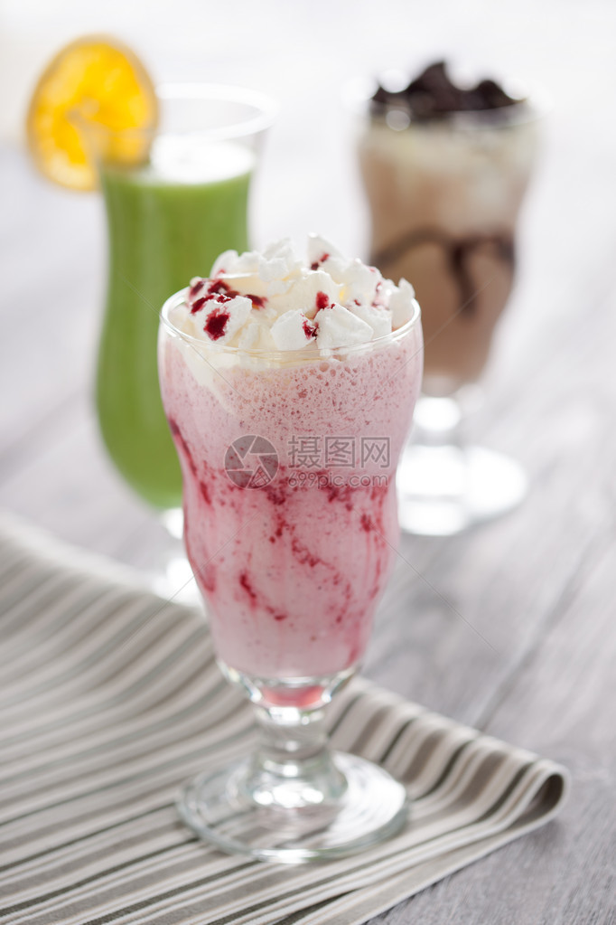 甜红莓鸡尾酒加鲜奶油和碎蛋白糖装在长玻璃杯里图片