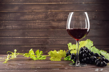 木桌上的酒杯和葡萄串图片
