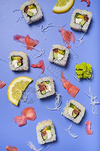 鲜蓝色背景中的寿司卷和配料背景图片