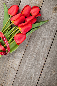 木桌背景上新红郁金香花束图片