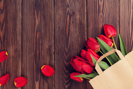 纸袋中的红色郁金香花束图片
