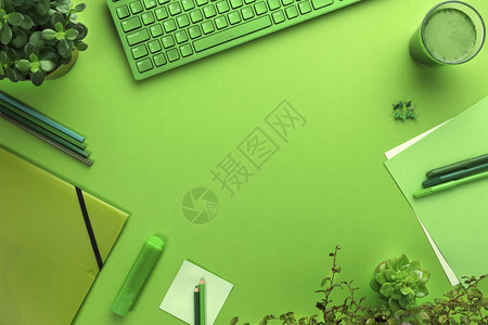 带电脑用品绿藻饮料和植物的绿色办公桌的环境概念的高角度视图图片