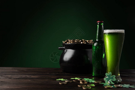 桌上有金币和绿色啤酒的罐子图片