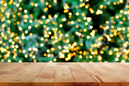 圣诞树上装饰灯带散景背的木桌顶图片
