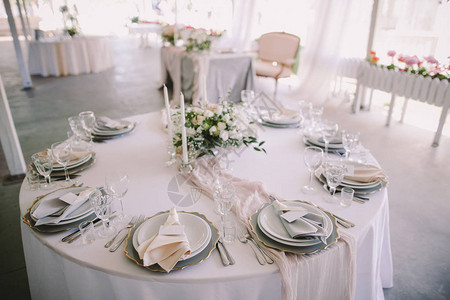在婚礼招待会上用餐具鲜花和蜡烛配图片