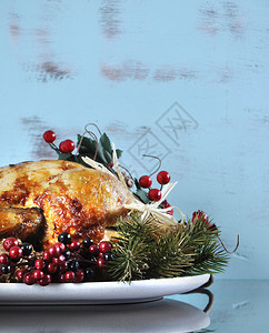 为感恩节或圣诞节午餐配上装饰品的烤火鸡盘子图片