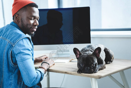 等待非裔美国人用电脑完成工作的无聊狗图片