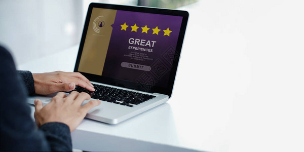客户体验概念现代商人通过笔记本电脑对客户满意度调查给予五星级评图片