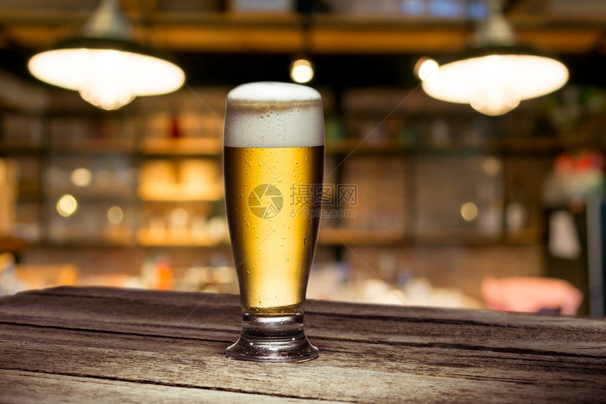 站在木制桌边的酒吧里啤酒杯图片