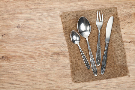 木桌上的银器或餐具套装叉子勺子和刀图片