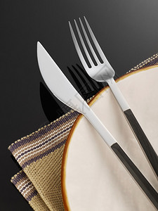 黑色背景中的叉子刀子和盘子图片