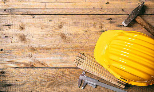 项目建筑工地木制桌上的黄色硬帽和工具复图片