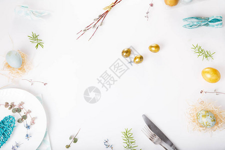 复活节餐桌设置与金色和蓝色鸡蛋和白色餐具假期背景背景与复制空间图片