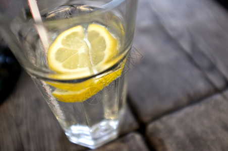 一杯水和木桌上的柠檬片背景图片