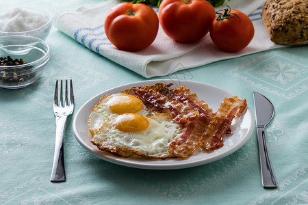 白盘上的培根和鸡蛋早餐图片