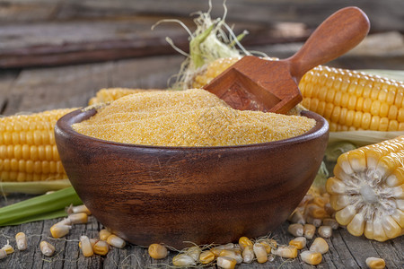 旧木桌上木碗里的玉米糁玉米粥图片