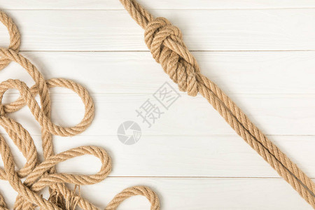 白色木板上棕色航海打结绳索的顶部视图图片