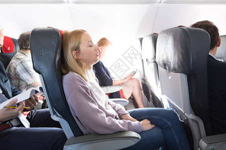 疲倦的金发碧眼的随便的caucasian妇女乘飞机时间高清图片素材