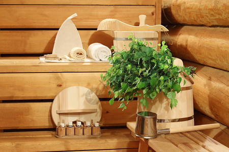 木桶上的新鲜桦木扫帚和桑拿浴室的洗浴用品图片