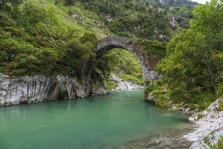 西班牙阿斯图里亚斯的古罗马石桥在河边的La图片
