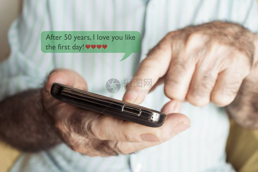 一个白人老在50年后用智能手机发送或阅读短信的特写我爱你就图片
