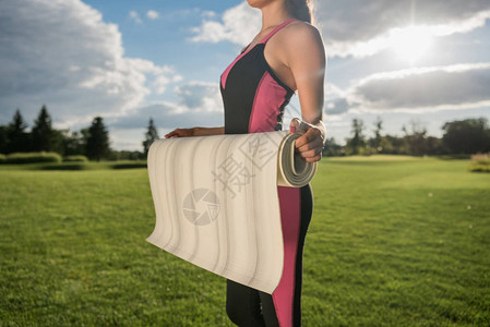 女运动员在公园内把瑜伽垫放在瑜伽垫图片