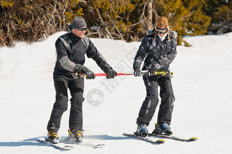 男滑雪教练年轻女子滑雪图片