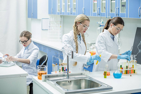 年轻女科学家与化学实验室试剂合作的图片