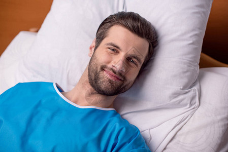 年轻的男病人躺在医院床上图片