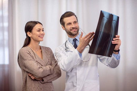 微笑的男医生和女病人在医院看图片