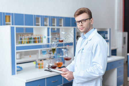 玻璃眼镜和实验室外套中的年轻男子科学家图片