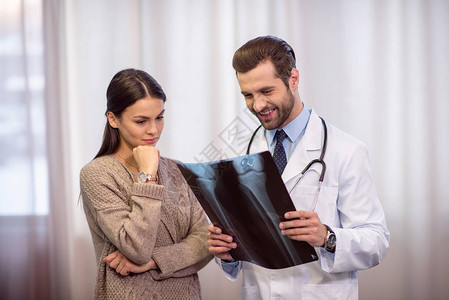微笑的职业男医生和女病人在医院图片