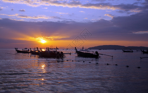 泰国日落时分在海边的长尾船图片