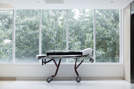 医院玻璃窗旁的空担架背景图片