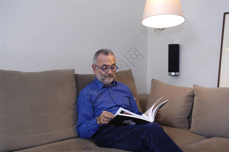 男人在沙发上放松和阅读背景图片