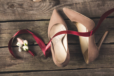 木制桌面上漂亮的新娘鞋和衣背景图片