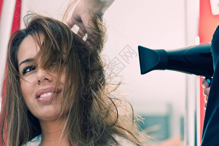美发师在美发沙龙吹干女头发图片