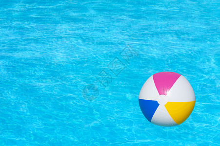 漂浮在游泳池里的充气彩色球图片