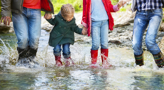 带着两个孩子的幸福家庭穿着雨靴图片