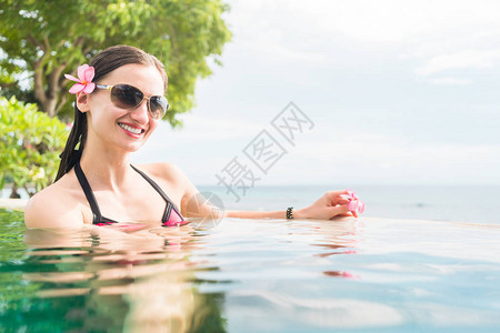 暑假的女子在泳池里游泳和背景图片