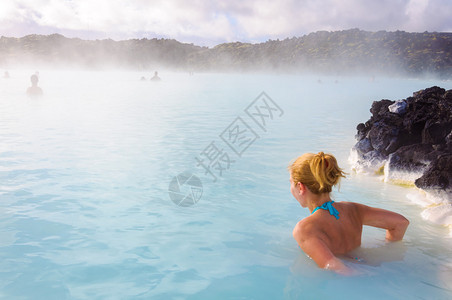 冰岛蓝湖地热温泉的年轻美女背景图片