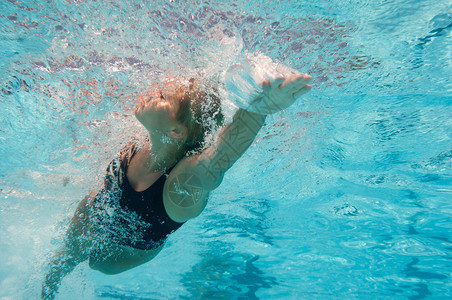 有吸引力的年轻女子在游泳池中游自由式游泳有选择的重图片