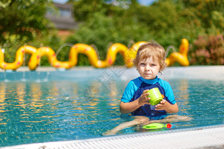 在户外游泳池边玩水的图片