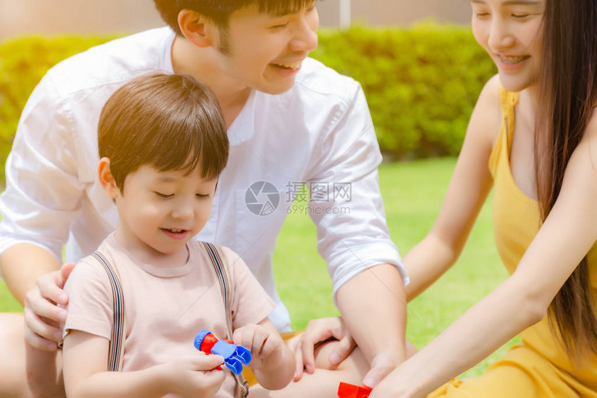 快乐的家庭英俊的小男孩或儿子在美丽的公园里和爸妈一起玩具可爱的孩子得到幸福图片