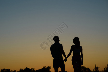 恋爱情侣在日落背景下行走图片